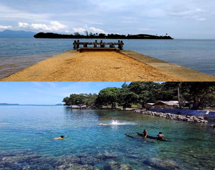 Jetty and village swimmers at East Cape, Milne Bay